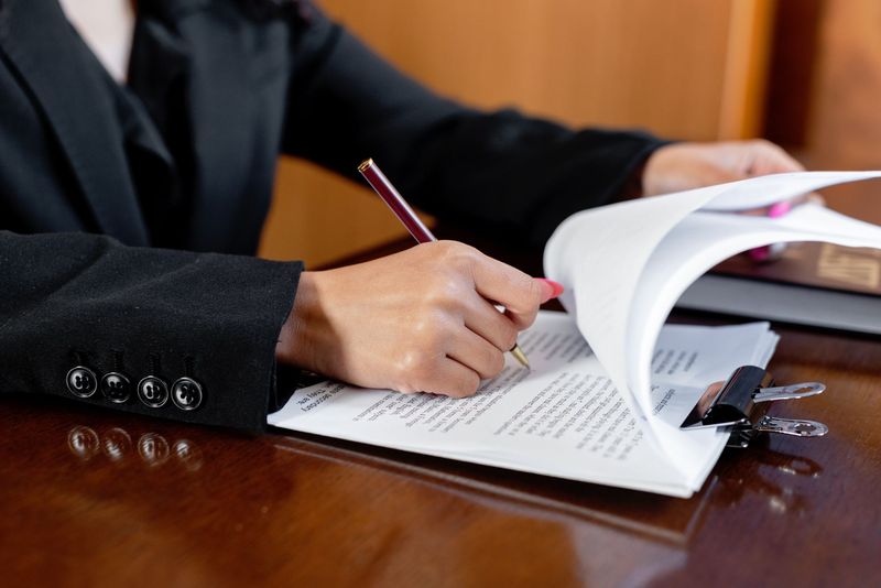 a signing agent reviewing a closing document page by page at a table